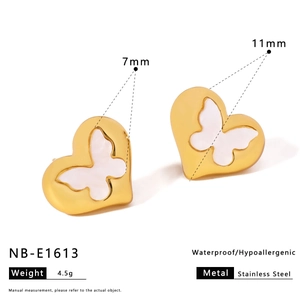 Macro detail of waterproof gold stainless steel heart earrings with white butterfly inlay