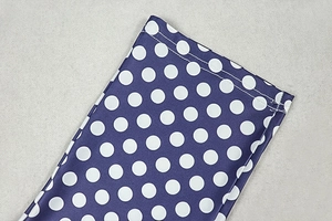 Detailed close-up of double-stitched hem on navy polka dot stretch fabric garment