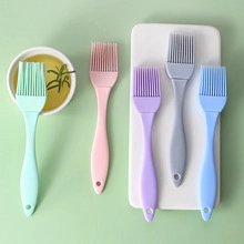 Flat lay macro of five colorful silicone oil brushes with handles and hanging holes