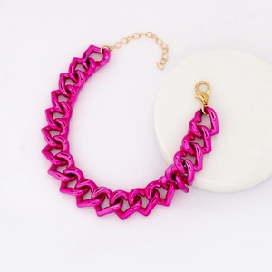 Detailed view of magenta heart-shaped linked pet necklace with a gold clasp on a pedestal