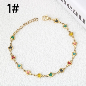 Dettaglio del bracciale in acciaio dorato con cuori in smalto colorato e chiusura