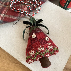 Detail of knitted Christmas tree pendant with wood buttons and a velvet ribbon bow