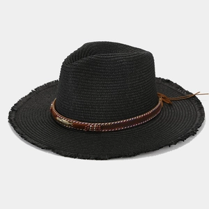 Detailed shot of a black straw hat with a feather buckle, beads, and frayed edges