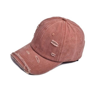 Close-up of distressed vintage washed cotton baseball cap with ripped details and frayed brim