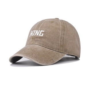Macro detail of KING embroidery on vintage washed khaki cotton baseball cap