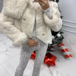 Detailed view of luxury white faux fur coat with gold buttons and lace pants