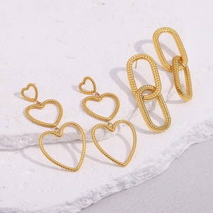 Detail of 18K gold-plated stainless steel heart and oval link earrings on stone