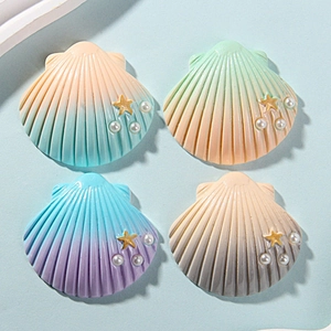 Detail of gradient resin shell charms with starfish and pearl accents for DIY crafts