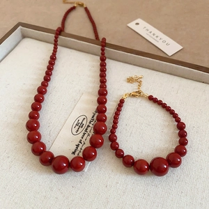 Gros plan d'un ensemble de bijoux en perles rouges avec perles dégradées et fermoir doré