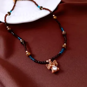 Collier éléphant vintage avec perles de grenat brun foncé et accents de cristal bleu