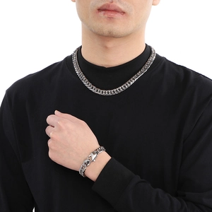 Men's silver polished Cuban chain necklace and bracelet set shown on model in black shirt