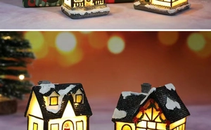 Detailed close-up of a resin Christmas house featuring LED lights and snow-covered roof