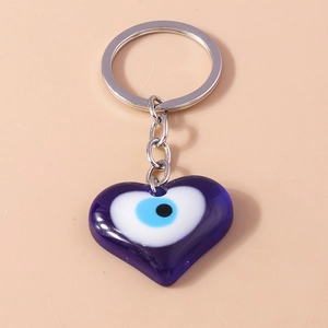 Detailed view of heart-shaped evil eye pendant with blue resin and silver metal keychain