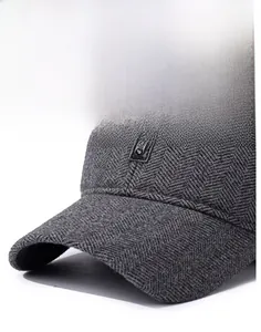 Detailed view of dark grey herringbone wool texture and Sport label on the baseball cap