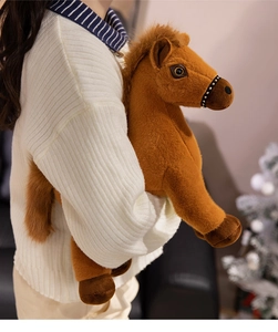 Gros plan détaillé d'une peluche de cheval marron tenue par un mannequin en studio
