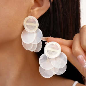 Fashionable white shell-like tiered circular drop earrings shown on a model