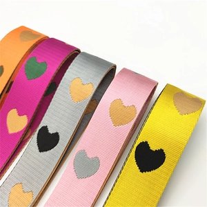 Dettaglio delle tracolle con motivo a cuore intrecciato e trama jacquard in vari colori
