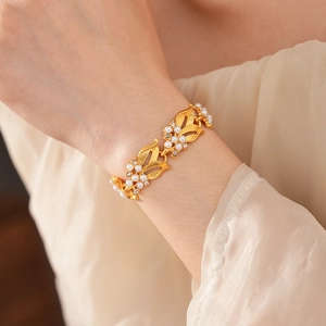 Detail of vintage gold-plated leaf bracelet with pearls and crystals on female wrist