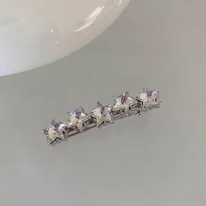 Macro detail of silver hair clip featuring five aligned sparkling pink crystal stars