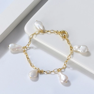 Détail des perles baroques et de la chaîne dorée sur un bracelet en argent 925