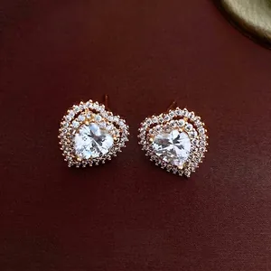 Elegant gold heart stud earrings with large central zircon and halo diamond setting