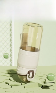 Detail of PPSU sports water bottle with non-slip sleeve on tennis court background