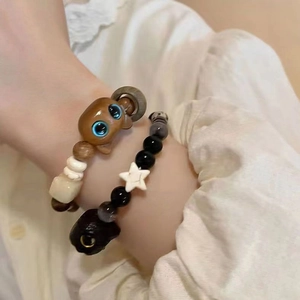 Detailed close-up of beaded bracelets with cat-shaped charms and star-patterned beads