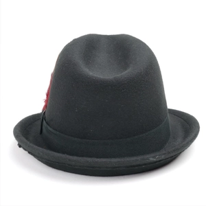 Close-up of black wool felt fedora featuring a decorative vibrant red feather detail
