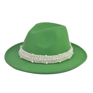 Detalle de sombrero de fieltro verde con adorno de perlas en el ala ancha