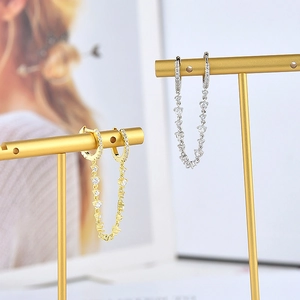 Macro shot of gold and silver S925 drop earrings with sparkling colorful zircon chains