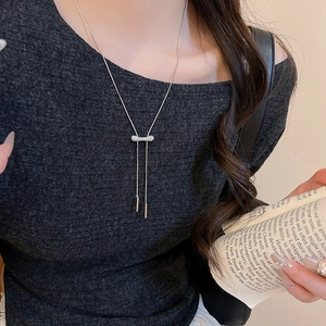 Vue détaillée du collier long en Y argenté avec barre en zircone sur haut gris