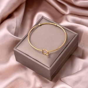 Detailed view of a gold heart knot bracelet displayed on a premium jewelry gift box