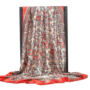 Detail of red and black paisley print silk satin square scarf with smooth texture