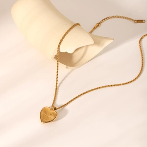Detail of 18K gold stainless steel heart pendant necklace with twisted chain texture
