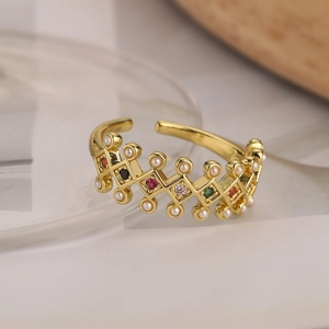 Detail of adjustable gold ring featuring multicolored cubic zirconia and faux pearl accents