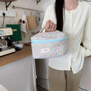 Close-up of quilted floral makeup bag with blue lavender pattern and top handle