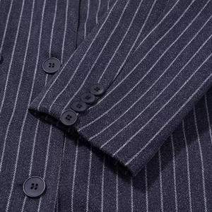 Detail eines dunkelblauen Nadelstreifen-Blazers mit Marineknöpfen und feiner Webstruktur