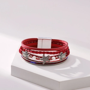 Detail of red multilayer leather bracelet with silver turtle and starfish charms