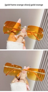 Detail of gold metal temples and orange gradient lenses with butterfly rhinestone accents