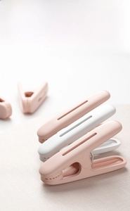 Close-up of matte plastic windproof clothespins in pastel pink and white minimalist design