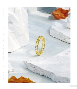 Detail showing gold hollow heart-shaped ring on white stone with artistic water shadows