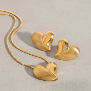 Detailed view of a gold heart-shaped jewelry set with necklace and matching stud earrings