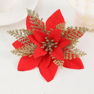 Artificial gold glitter poinsettia flower for Christmas tree decoration on white surface