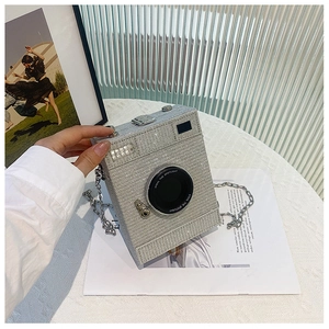 Detailed macro view of silver crystal encrusted camera shaped handbag with metal chain
