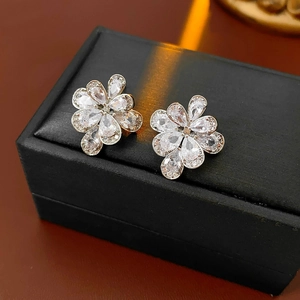 Dettaglio di orecchini a fiore in argento con zirconi scintillanti su scatola nera