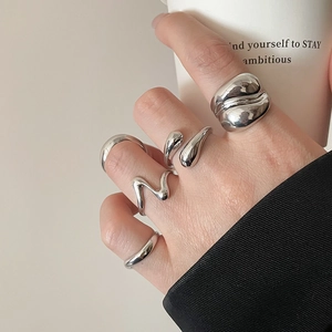 Silver minimalist ring set featuring fluid shapes and deconstructed aesthetic on model