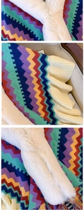 Detail of colorful knitted wavy stripes and thick white faux fur on a vintage poncho scarf