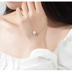 Detailed view of cherry blossom necklace featuring mother of pearl and diamond-set petals
