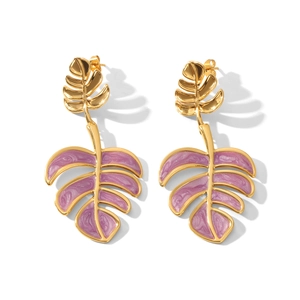 Macro detail of leaf-shaped monstera earrings with purple enamel and gold-plated finish