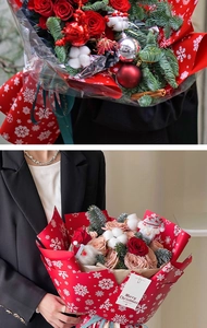 Detail of Christmas flower bouquet with red roses, pine branches and snowflake wrapping paper